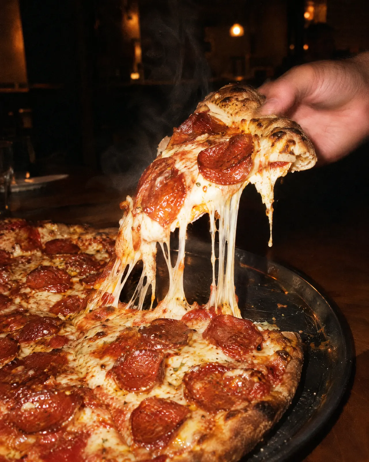 Fatia de pepperoni saindo da pizza com o queijo esticando