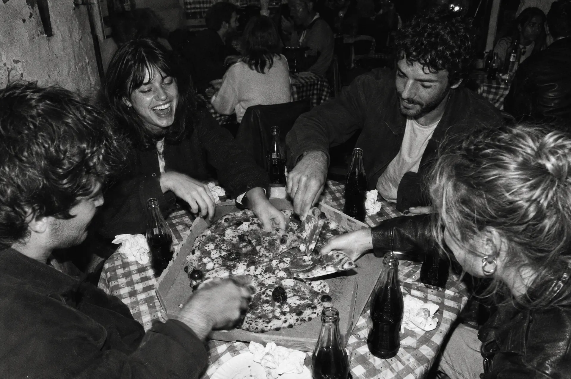 Amigos dividindo uma pizza na mesa
