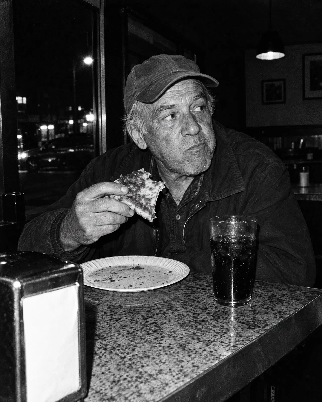 Senhor de boné comendo no balcão